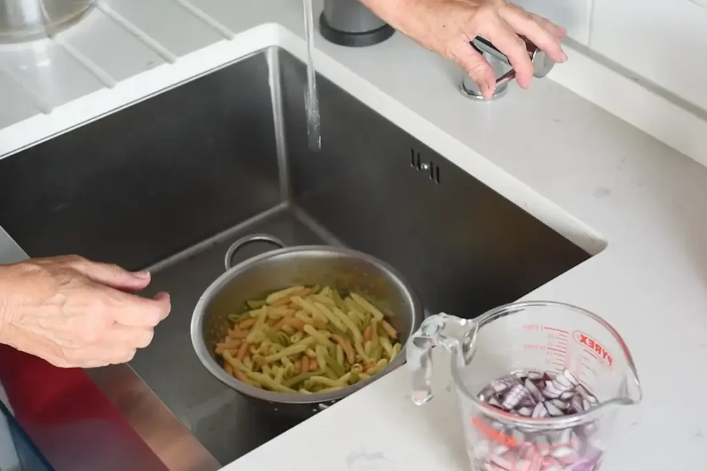 the pasta using the hot pasta water to blanche the raw onion